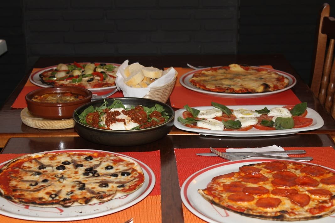 Mesa de Il Nuraghe servida con varios platos y pizzas