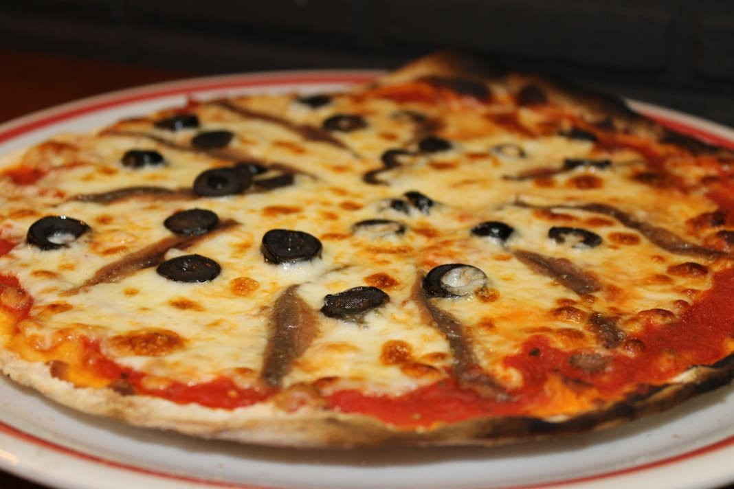 Pizza siciliana de masa fina con anchoas y aceitunas negras