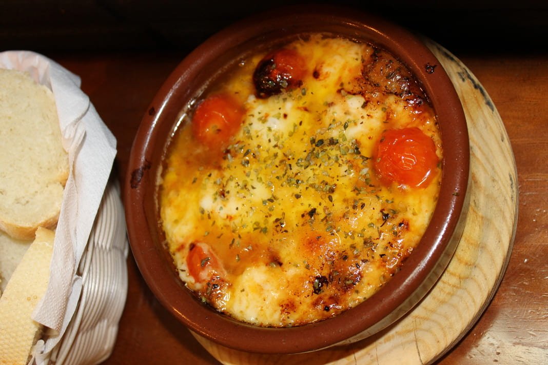 Provoleta fundida con tomates cherry y orégano